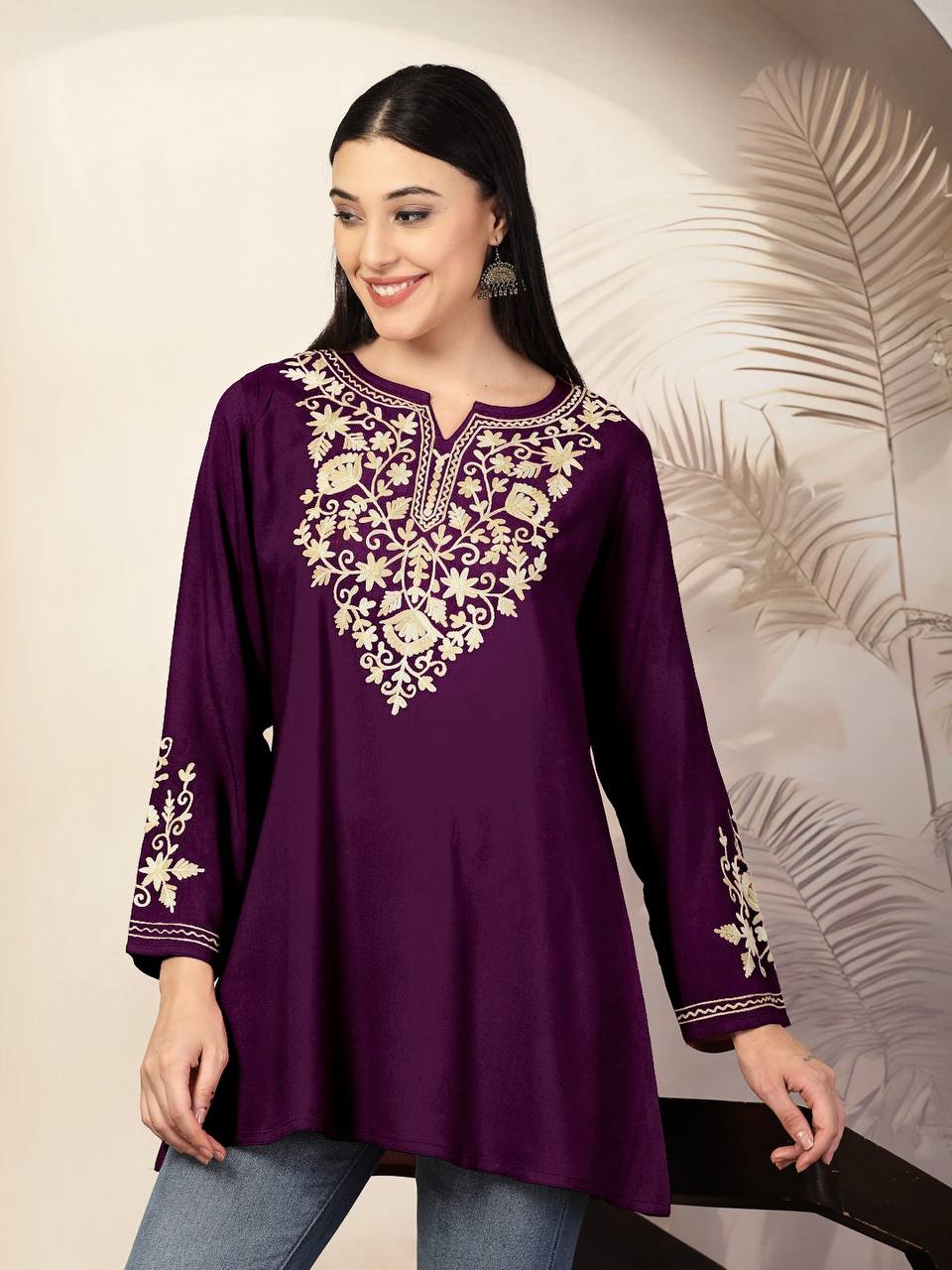 Purple Adaa ShortKurti featuring rich gold embroidery on the neckline and sleeves, paired with blue jeans.