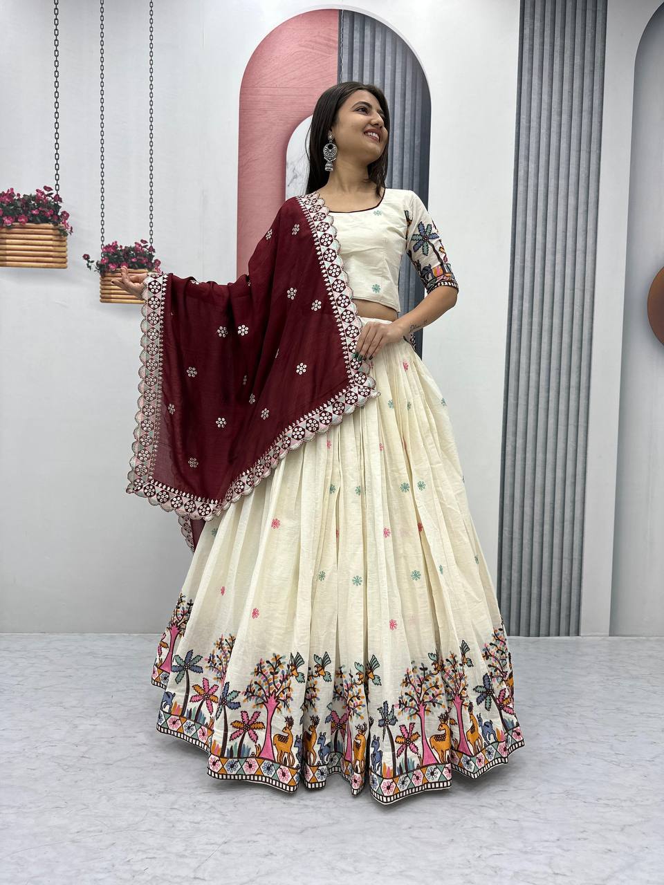 Smiling woman in ivory Rangbhoomi Lehenga with maroon dupatta. Festive cotton embroidery choli design.