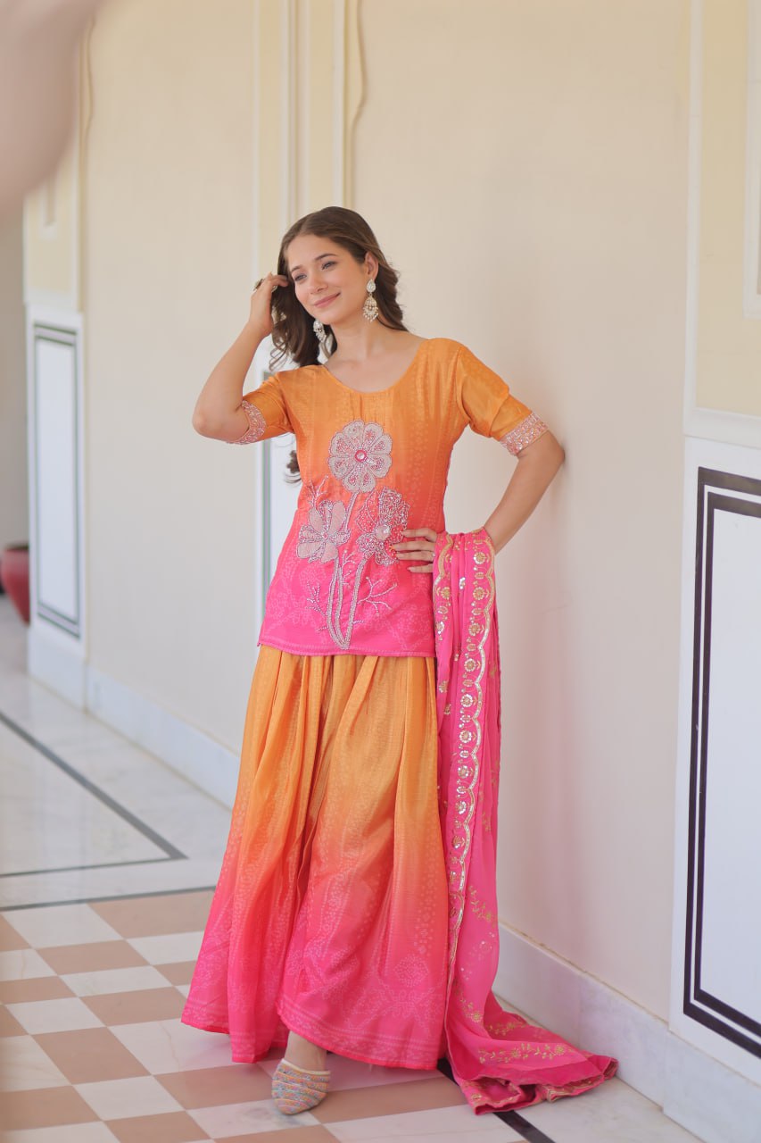 Model leaning in Sharara Suit with pink dupatta and embroidery