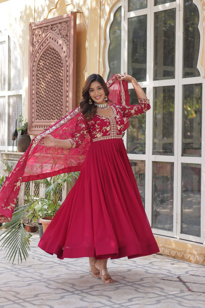 Model twirling in a flowing pink embroidered Indian gown with dupatta.