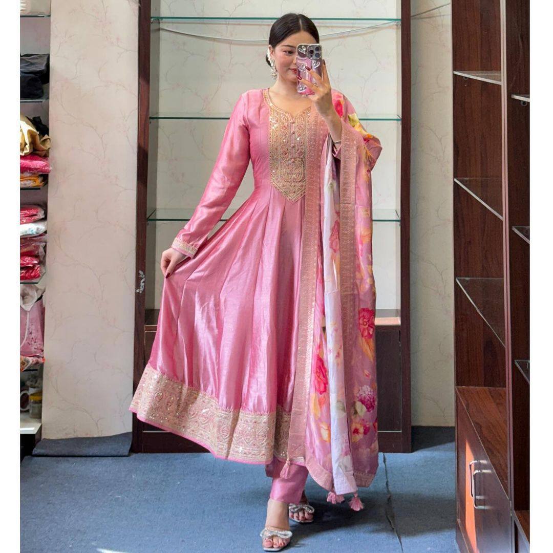 Full view of a woman in a pastel pink Anarkali suit with floral dupatta.