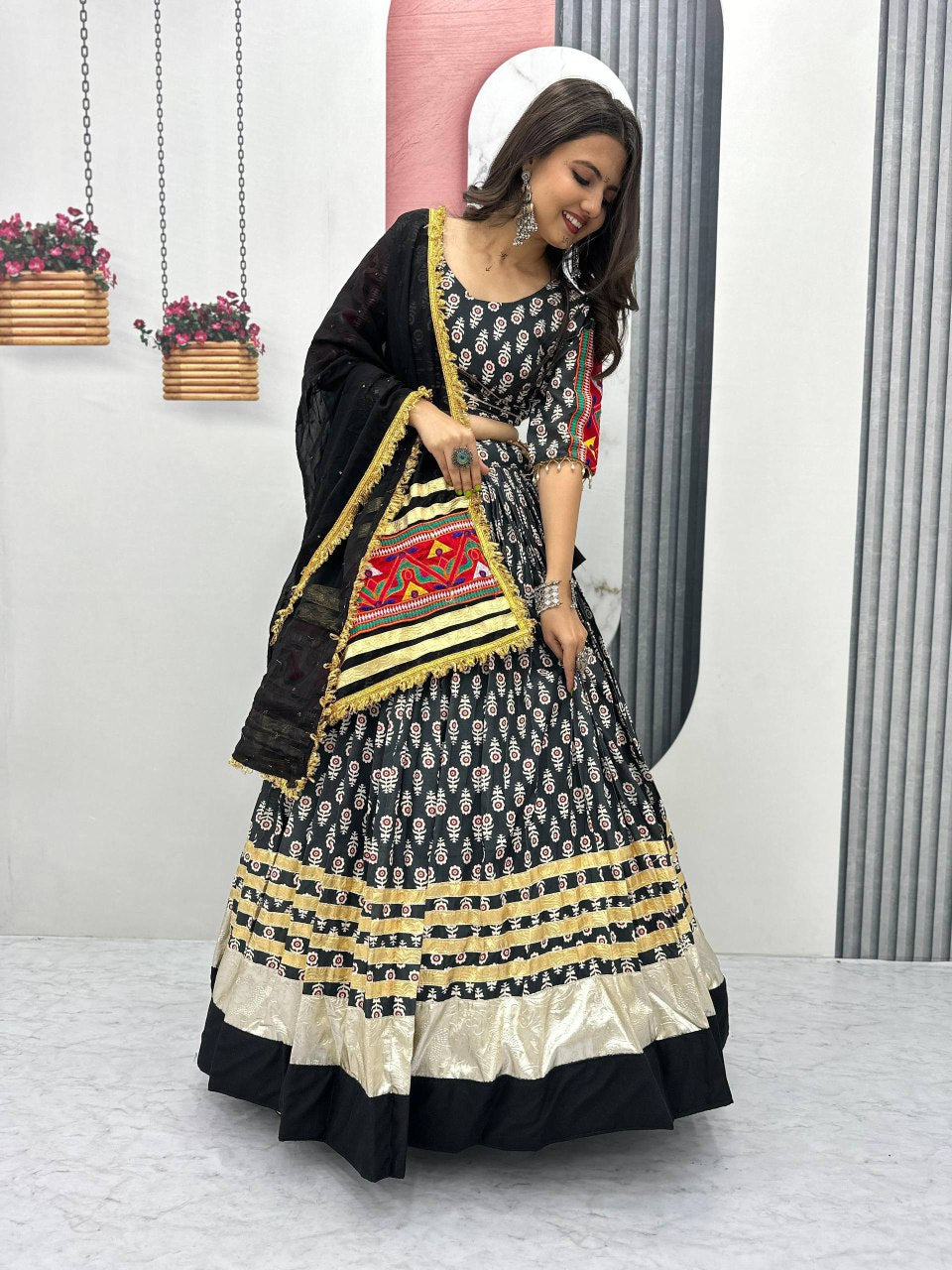 Smiling woman in festive Gamathi Glam lehenga choli, featuring intricate gold details and a colorful dupatta.