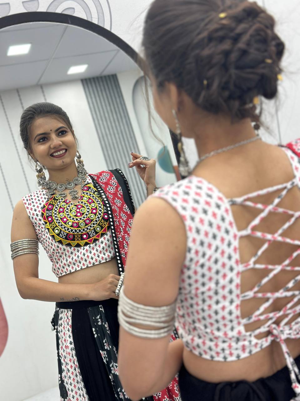 Back view of choli with adjustable tie, mirror embroidery, and front reflection in lehenga choli set.