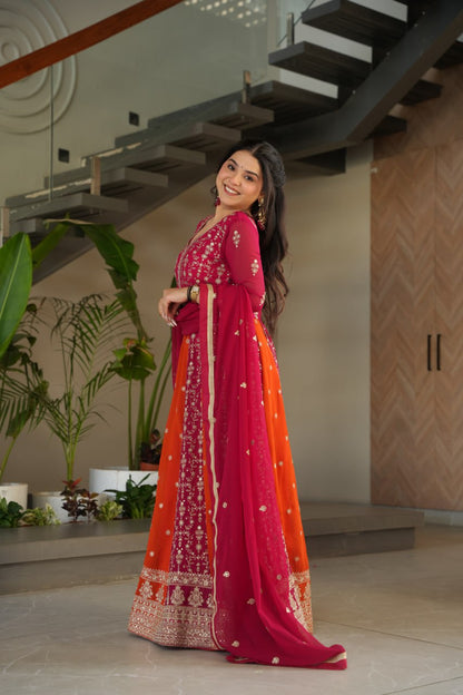 Woman wearing a pink and orange gown with zari and sequin embroidery.