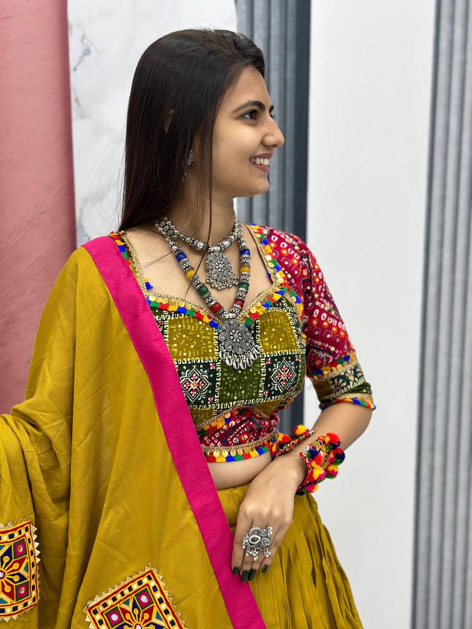 Smiling woman in traditional mustard cotton choli with Gamthi work and silver jewelry.