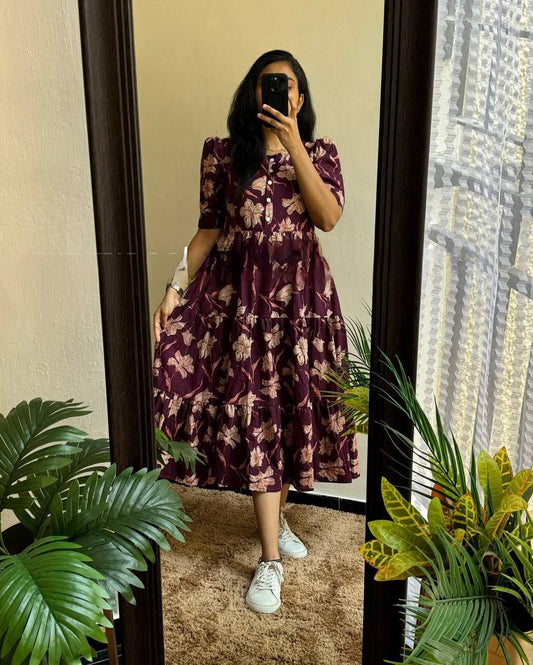 Moringa Maxi dress in a mirror reflection. The dress is plum with a floral pattern and short sleeves.