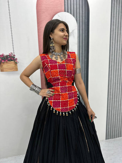 Close-up of red and orange patterned choli with shell lace detail and black lehenga, styled for Navratri.
