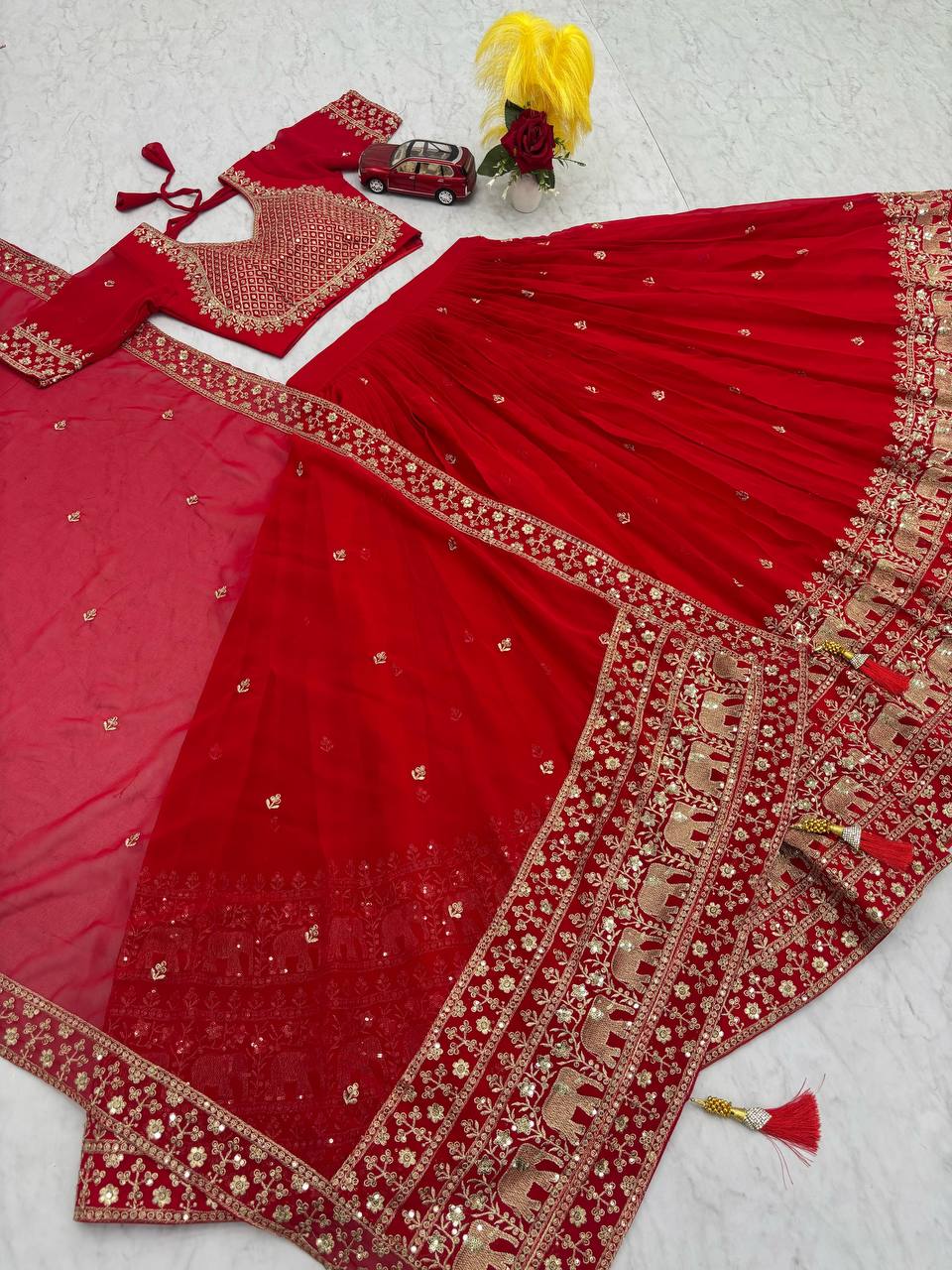 Red lehenga choli set with dupatta and gold elephant embroidery.