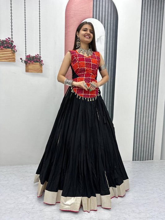 Woman wearing black pure cotton lehenga with gold border and vibrant red printed choli, ready for Navratri.