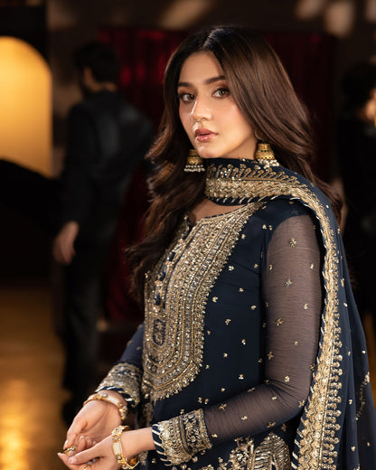 Close-up of gold sequin embroidery on navy blue sharara set, highlighting intricate neckline and sleeves.