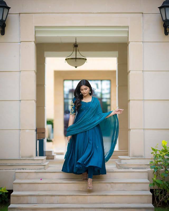 Model in Morpankh Anarkali, walking down steps.