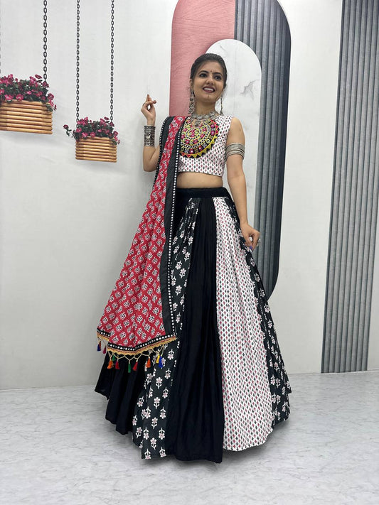 Woman wearing black, red, and white folk print lehenga choli, red dupatta, and silver jewelry.