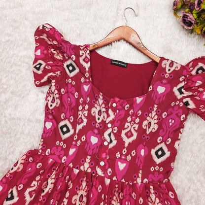 Dhano Maxi pink Patola dress on a hanger, showcasing the fabric and design.