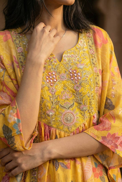 Yellow heavy crepe kaftan with intricate pink floral embroidery and mirror work on the bodice.