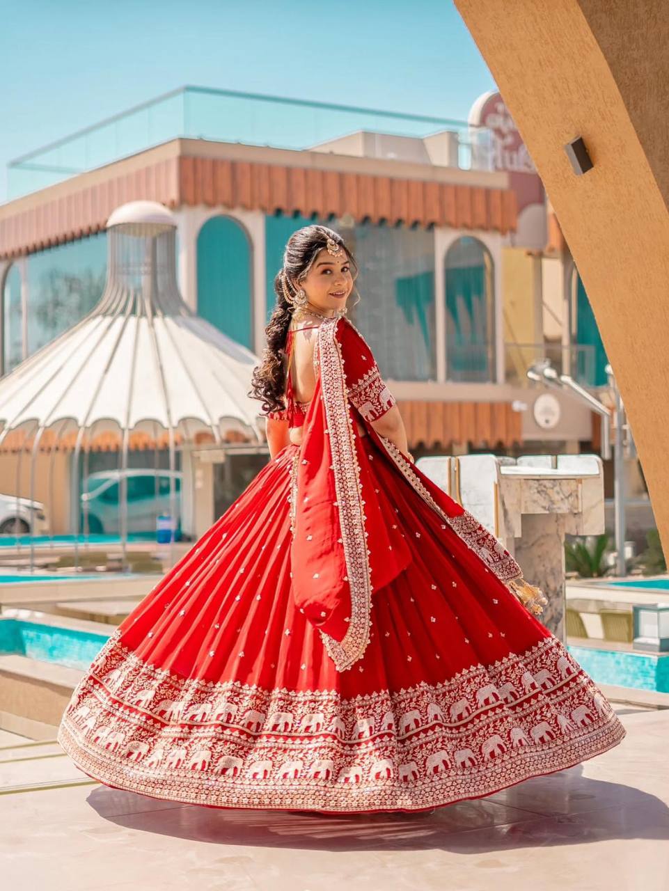 Back view of red embroidered lehenga choli with detailed dupatta.