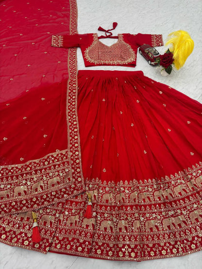 Red lehenga choli set with gold elephant embroidery and tassels.
