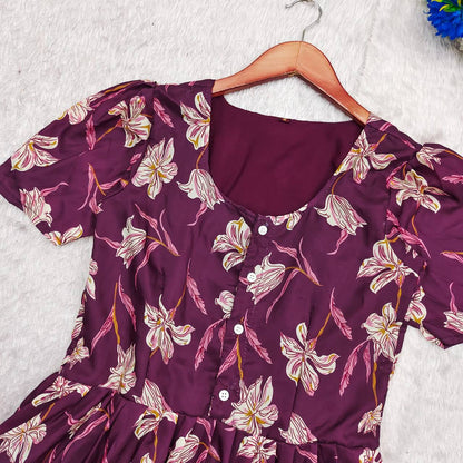 Close-up of the Moringa Maxi dress showing the neckline, buttons, and floral pattern in plum.