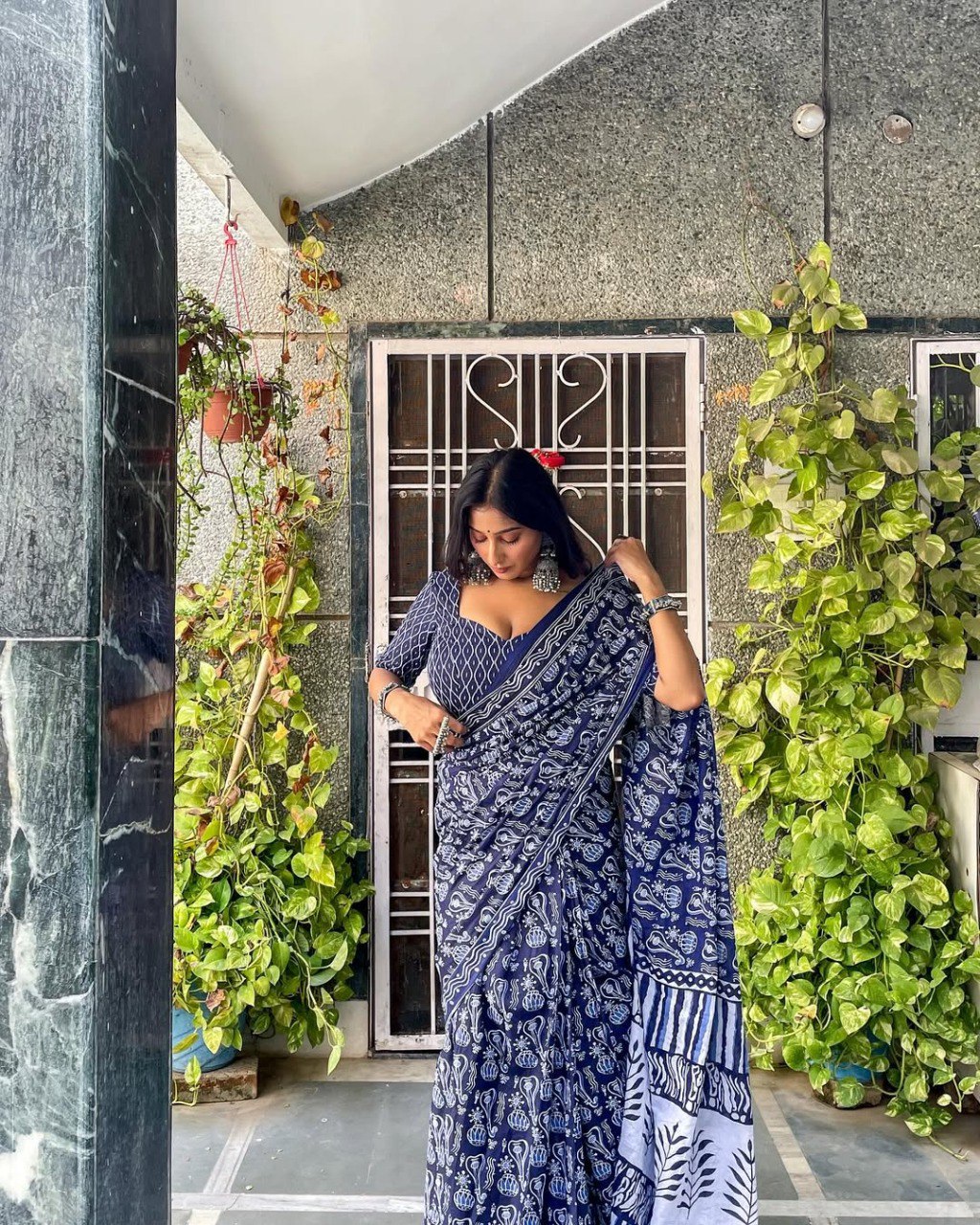 Model wearing a pre-stitched blue and white cotton saree with adjustable waist.