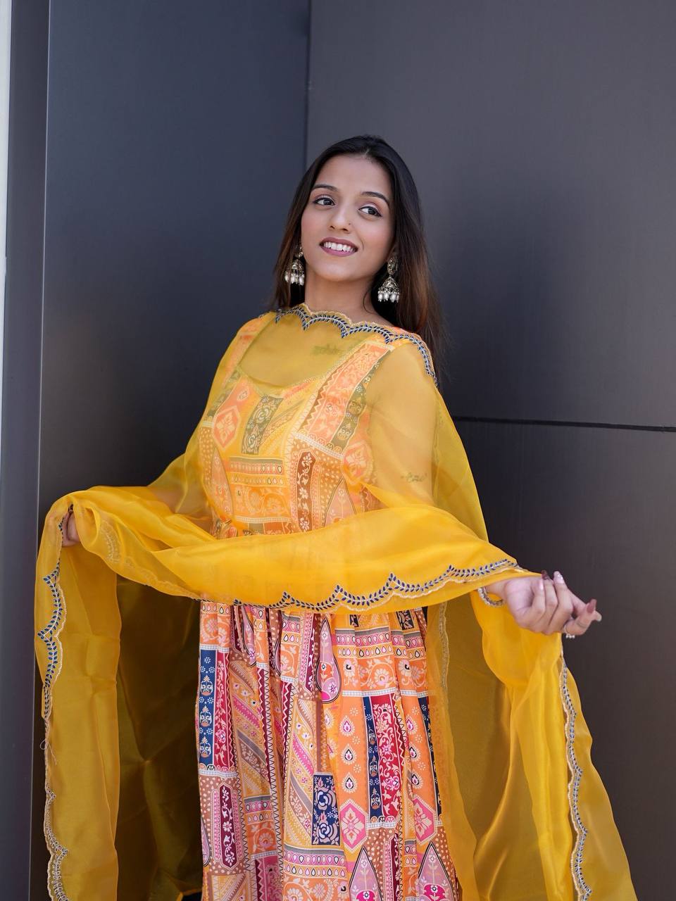 Back view of yellow Anarkali suit showing flared silhouette and dupatta detail.