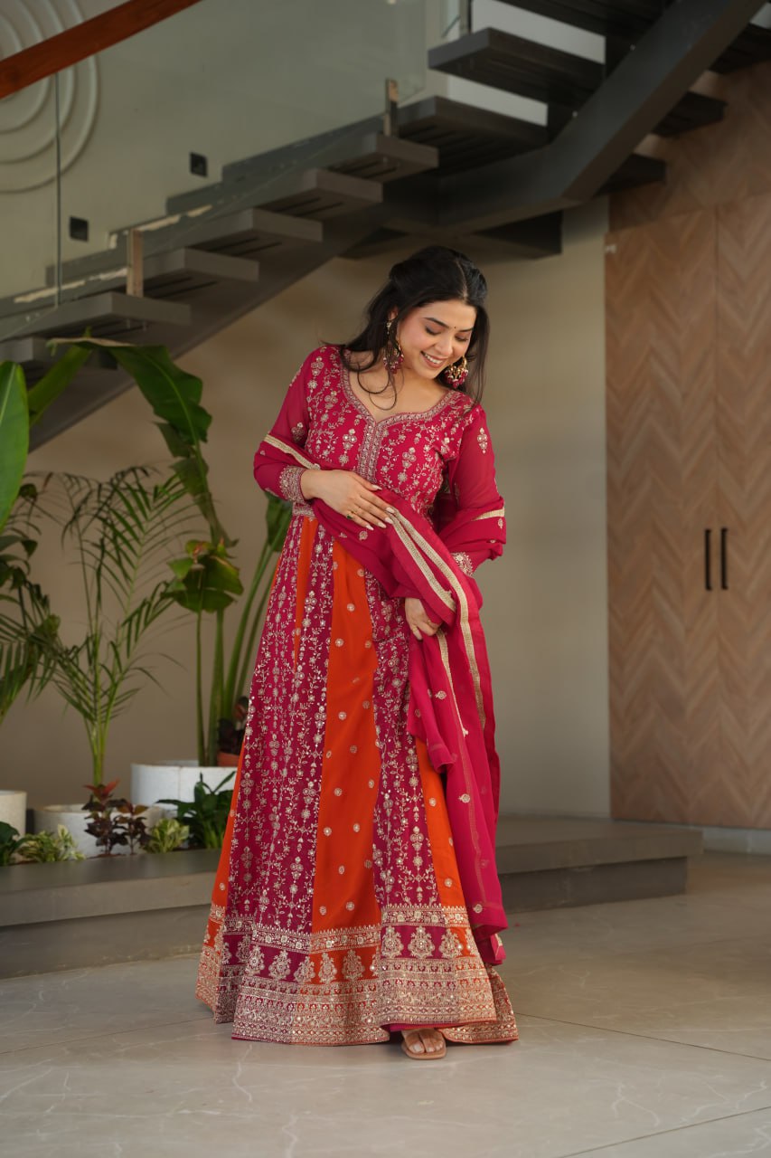 Woman wearing a pink and orange embroidered designer gown and dupatta.
