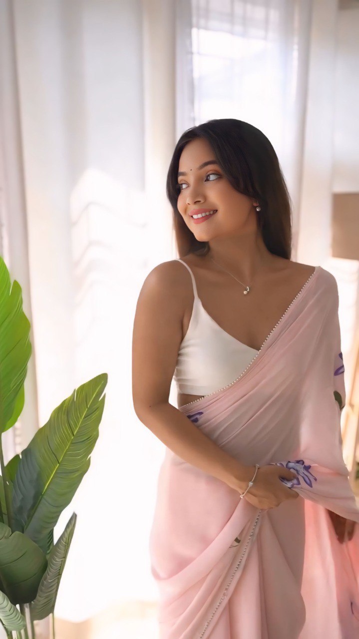 Smiling model in a pink georgette ready-to-wear saree with floral design.