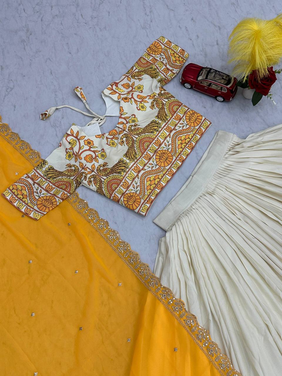 Top-down shot of Kalamkari lehenga choli set with yellow dupatta.