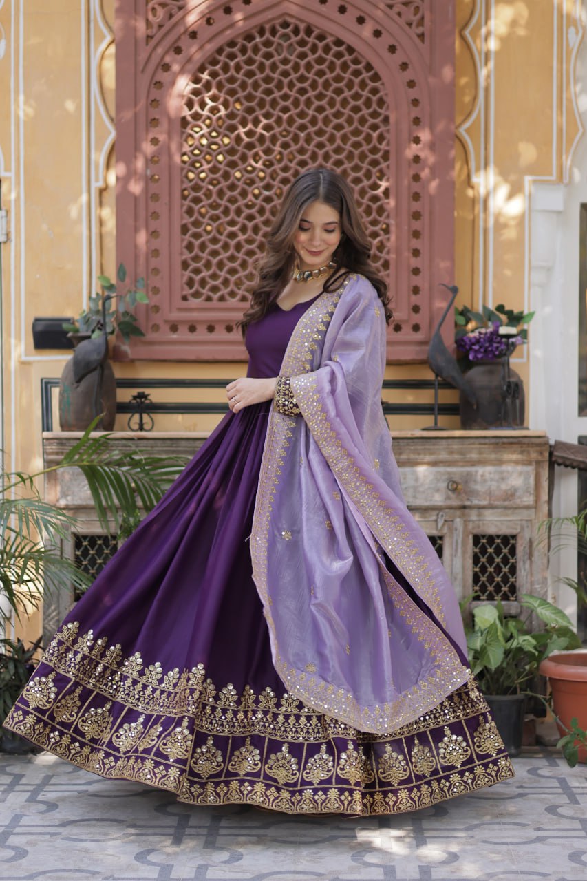 Model smiling in an elegant purple gown and light purple dupatta.