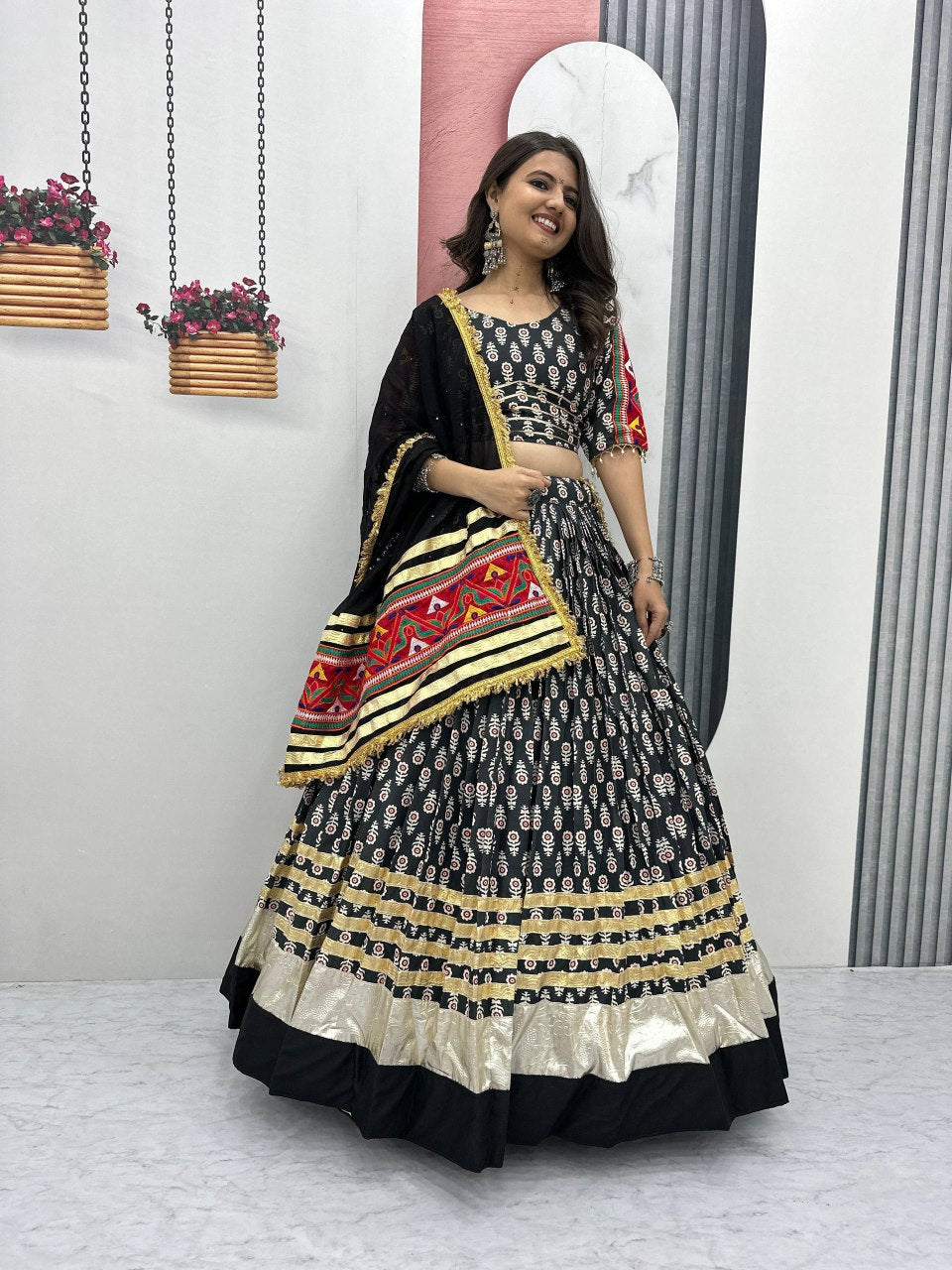 Woman wearing Gamathi Glam black lehenga choli with gold border and embroidered dupatta, perfect for Navratri.