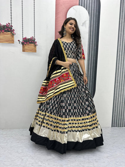 Woman wearing Gamathi Glam black lehenga choli with gold border and embroidered dupatta, perfect for Navratri.