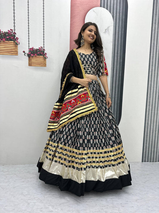 Woman wearing Gamathi Glam black lehenga choli with gold border and embroidered dupatta, perfect for Navratri.