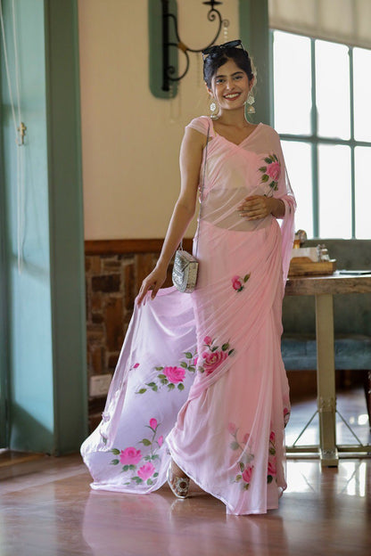 Woman wearing a pink georgette rose saree and silver purse.