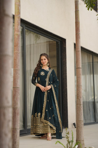 Woman wearing a Rama green designer gown and dupatta with jewelry.