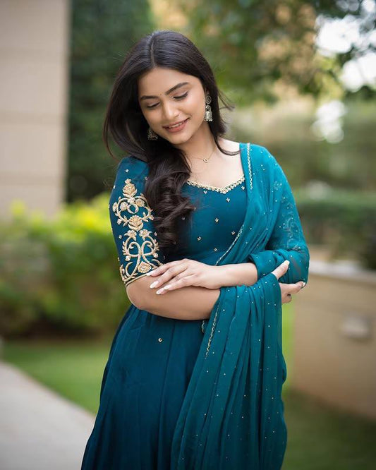 Model wearing a teal Morpankh Anarkali with gold embroidery.
