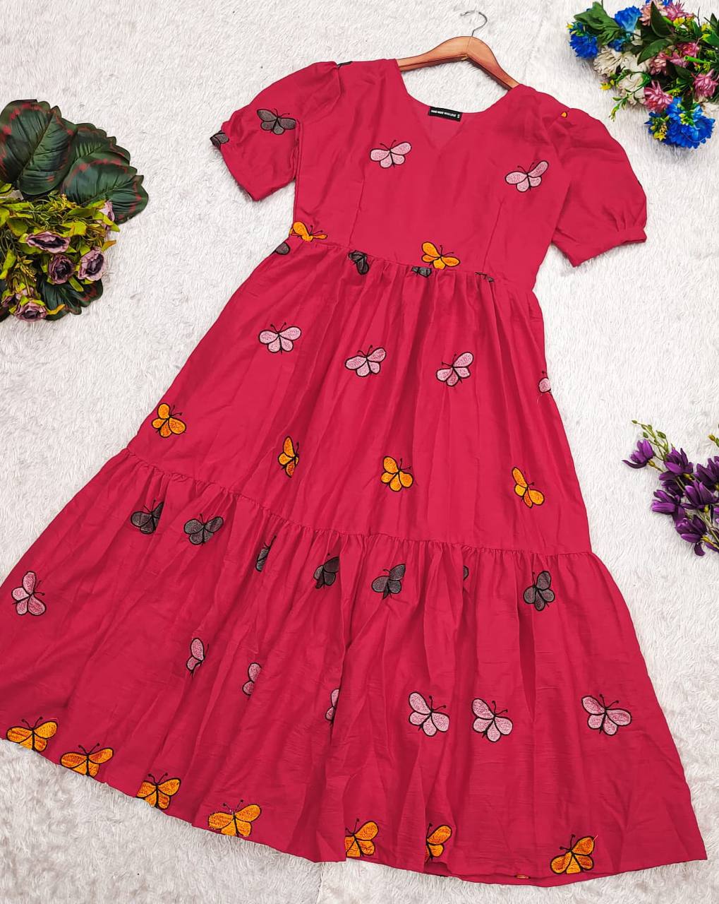 Pink Butterfly Maxi Dress laid flat, displaying the all-over butterfly print and tiered design.