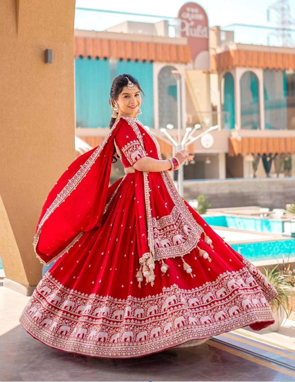 Red embroidered lehenga choli set with elephant design.
