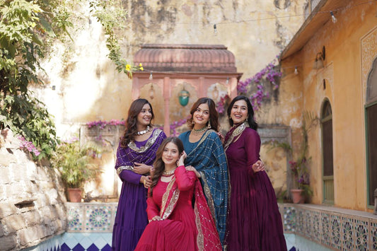 Group of women wearing flared gowns with embroidered dupattas in various colors.