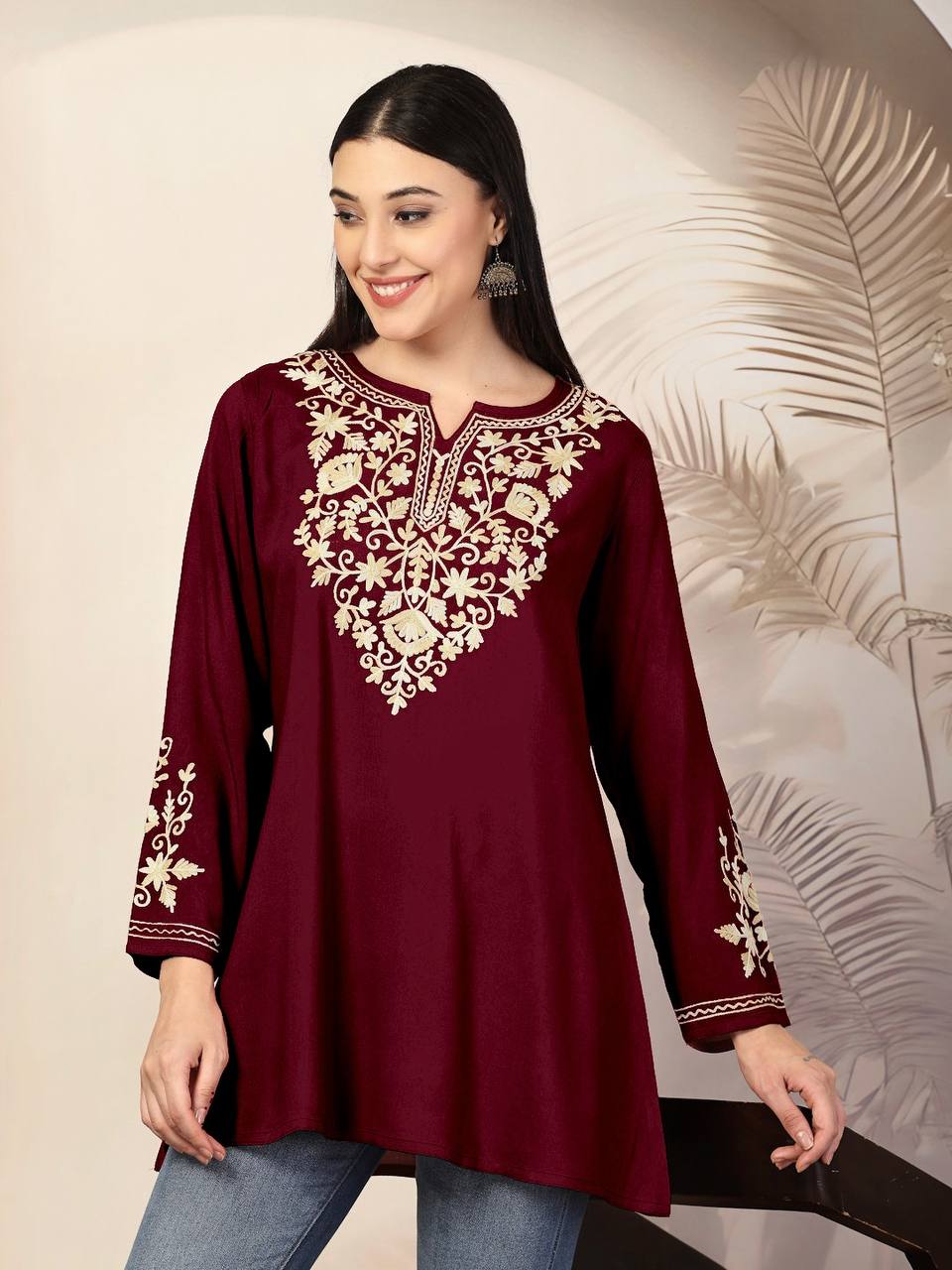 Maroon Adaa ShortKurti with intricate gold floral embroidery, long sleeves, and a relaxed fit, styled with jeans.
