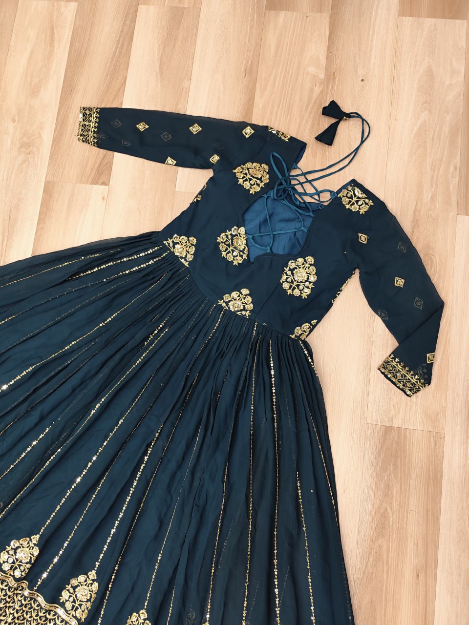 Back view of the Rama green designer gown featuring intricate zari embroidery and tie details.