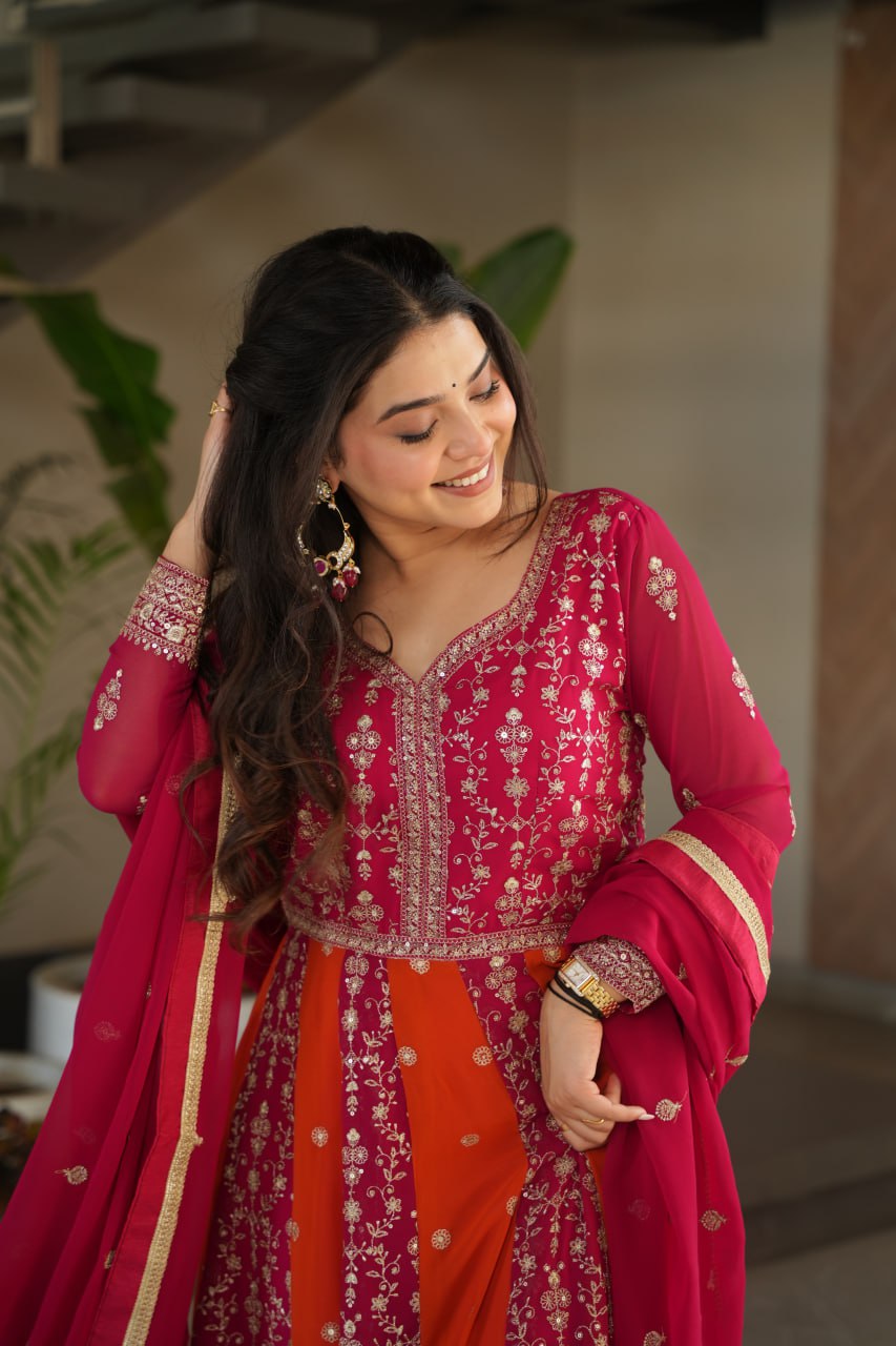Close-up of a woman in a pink and orange zari embroidered gown.