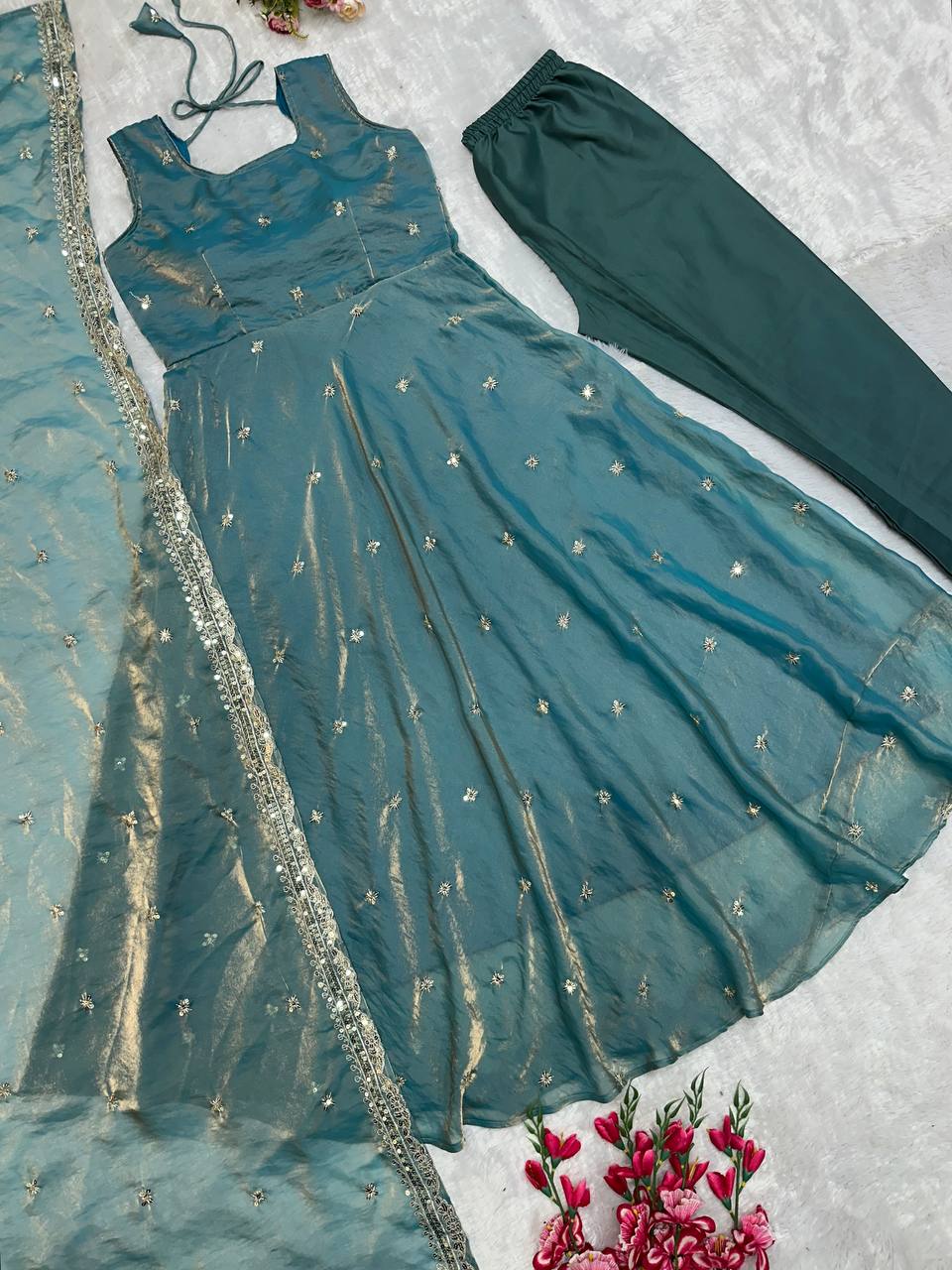 Elegant designer gown ensemble in teal with embroidery.