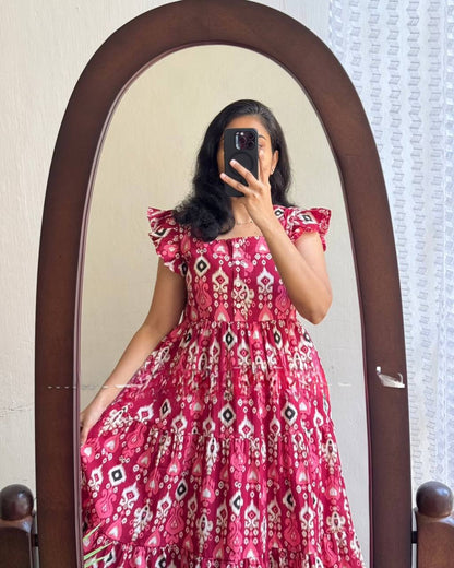 Close-up mirror shot of woman in Dhano Maxi pink Patola dress.