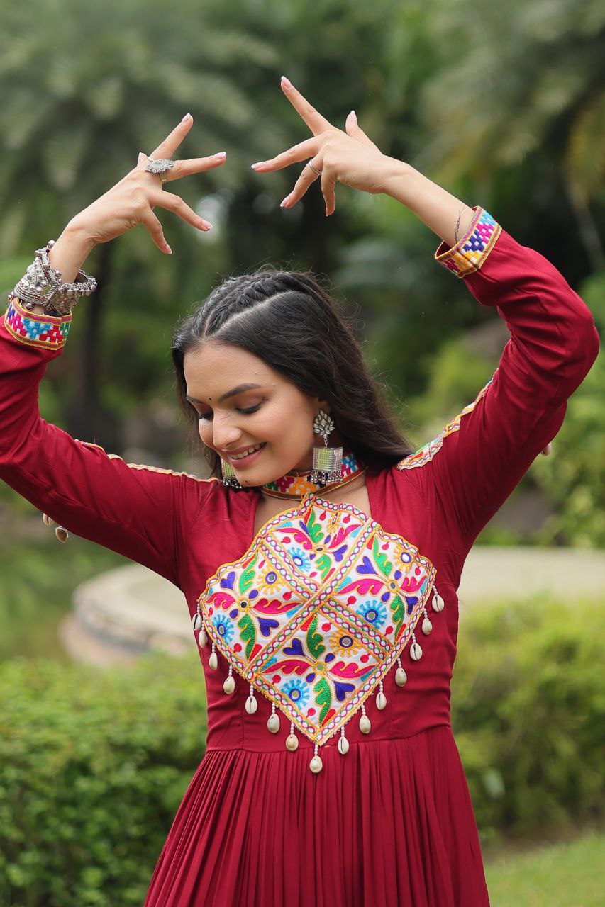 Close-up of maroon Gamthi Gown bodice with detailed Kutchi embroidery, mirror work, and pearl drops.