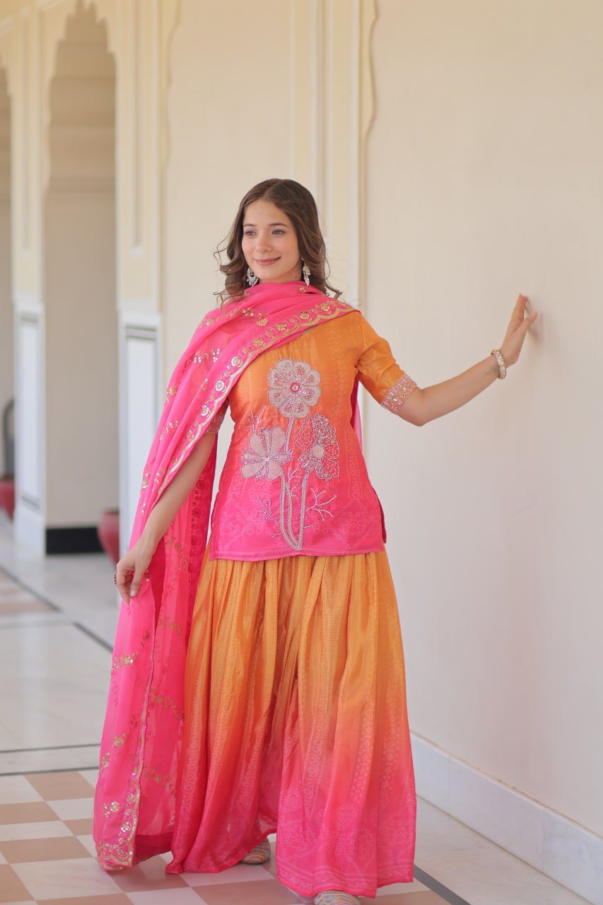 Model wearing Sharara Suit with pink dupatta and silver earrings