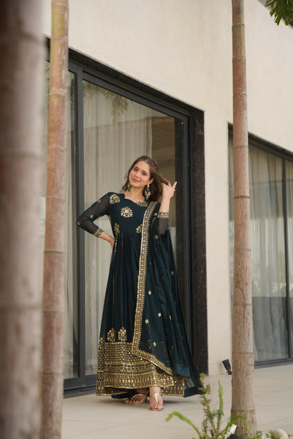 Woman in a Rama green gown and dupatta, smiling and posing outdoors.