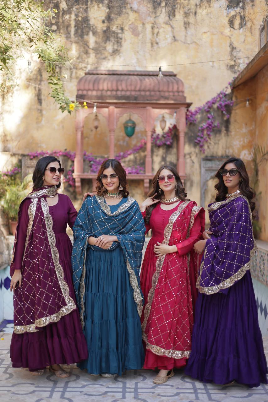 Four women in sunglasses wearing purple, teal, and red embroidered dupatta gowns.