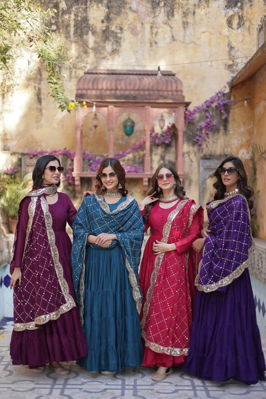 Four women in sunglasses wearing purple, teal, and red embroidered dupatta gowns.