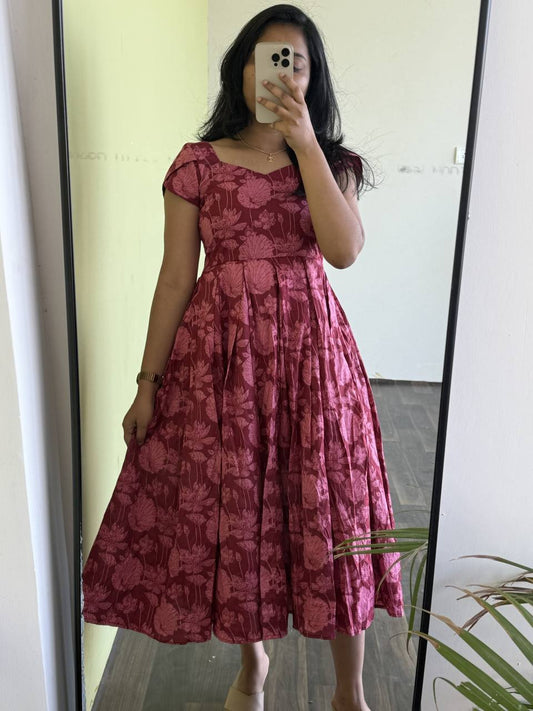 Maroon Lotus dress on model. A-line floral dress with short sleeves and a flattering silhouette.