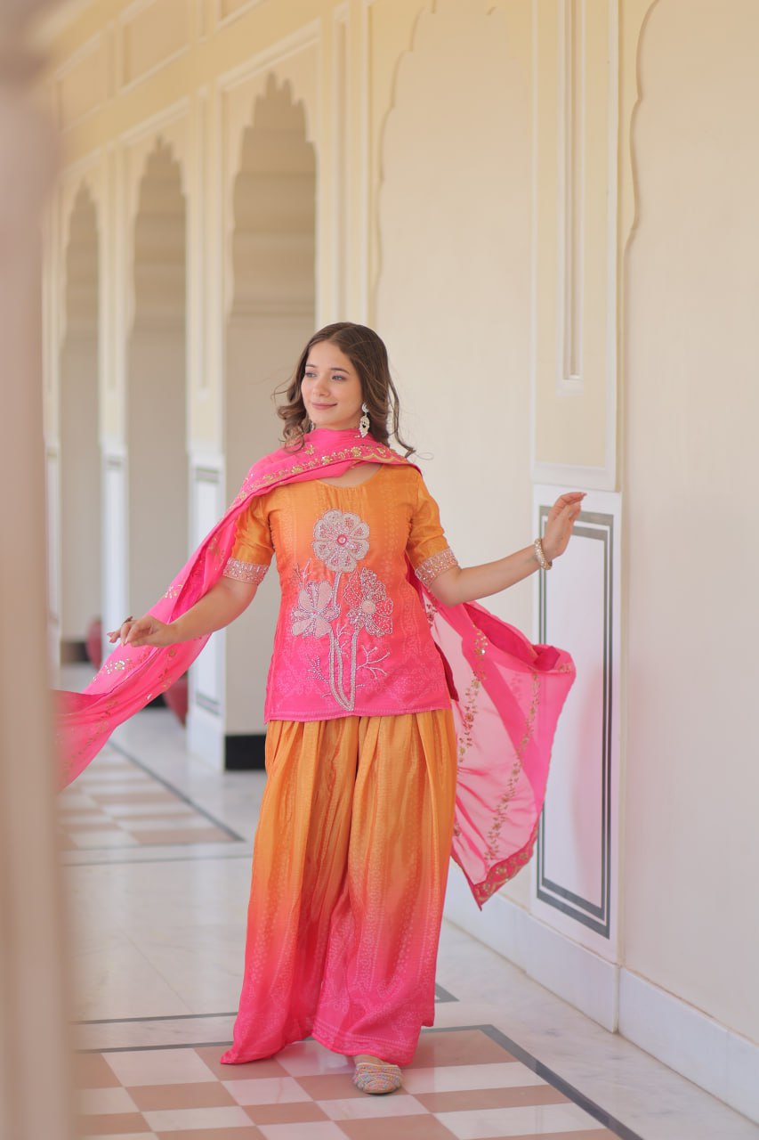 Woman in stylish Sharara Suit with floral embroidery and pink dupatta