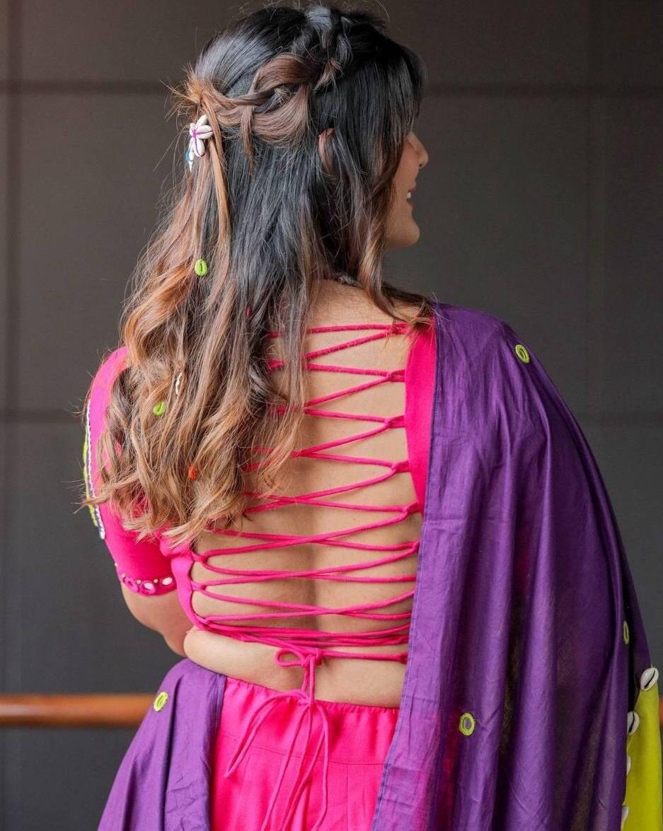 Rear view of pink blouse with crisscross back ties and purple dupatta, highlighting unique festive design.