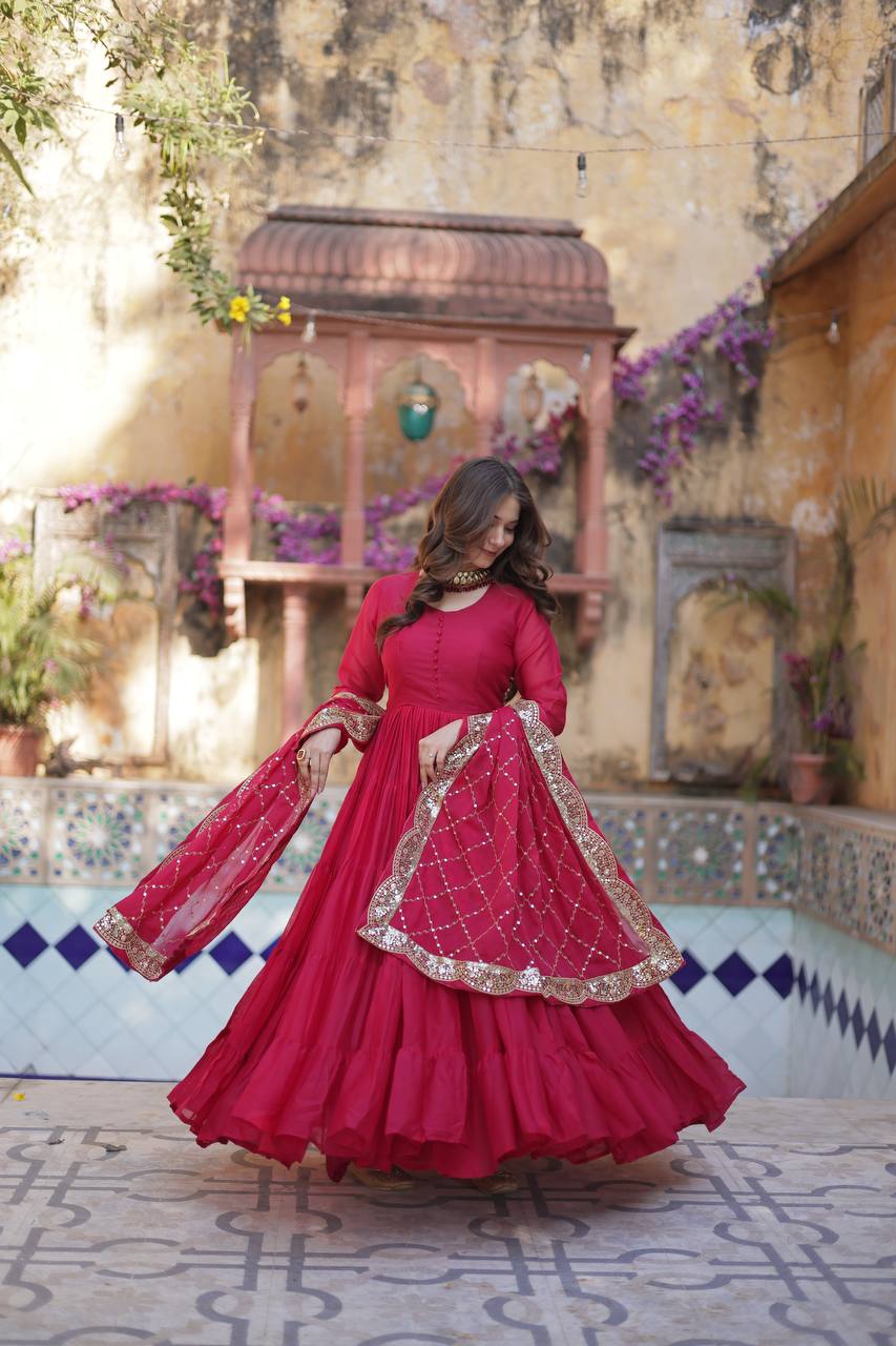 Woman twirling in a red flared gown with a gold embroidered dupatta, full flair.